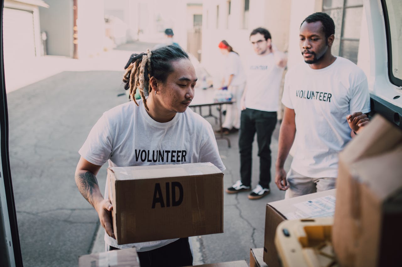 Volunteers unload aid supplies from a van, showcasing teamwork and community support.